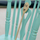 a wooden spoon with a face drawn on it, sitting on a wooden chair